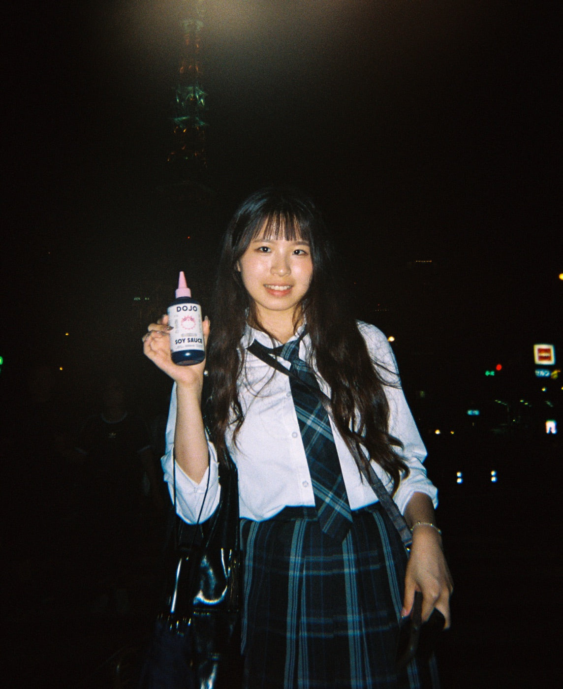 A student in uniform holding the Dojo bottle at night